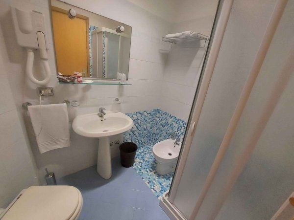 Bagno moderno con doccia e mosaici blu.