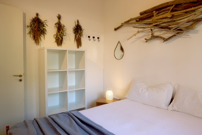 Letto con decorazioni in legno e scaffale bianco.