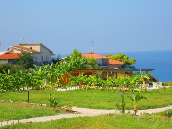 Paesaggio con giardino, case e vista mare.