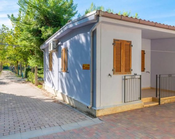 Casa blu con persiane marroni e vialetto di mattoni.