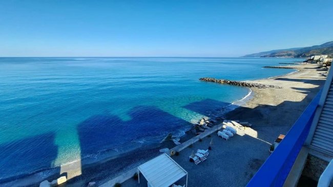 Spiaggia e mare blu con rocce.