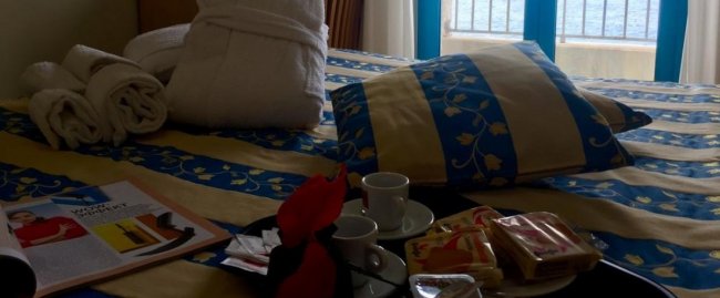 Camera con letto, vassoio da tè e vista mare.