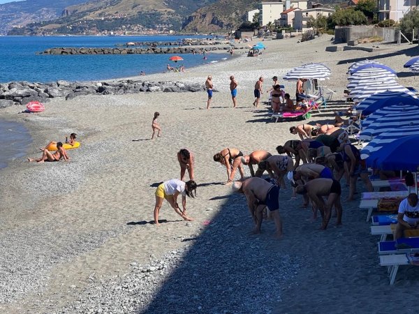 Persone fanno esercizi su una spiaggia.