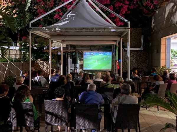 Proiezione di una partita su uno schermo all'aperto.
