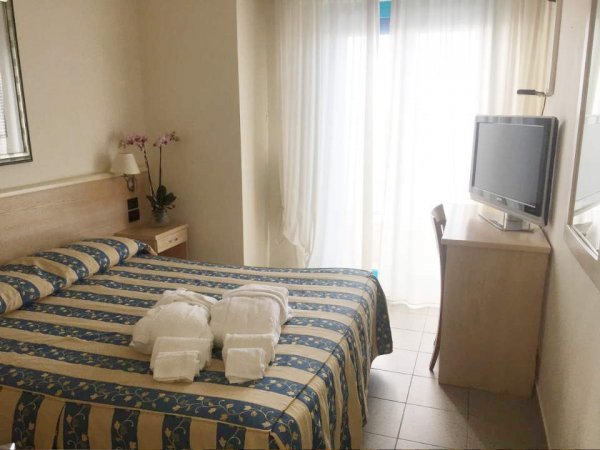 Camera d'albergo con letto matrimoniale e TV.