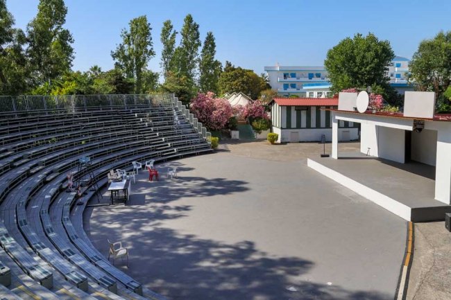 Un anfiteatro all'aperto con sedili in metallo e palco.