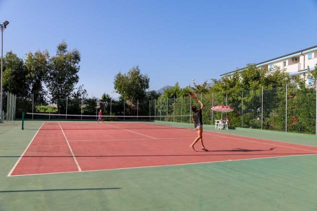Due persone giocano a tennis all'aperto.