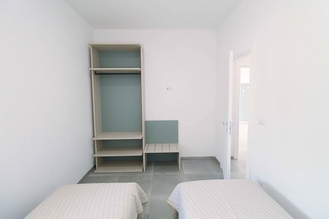 Camera con due letti singoli e armadio aperto.