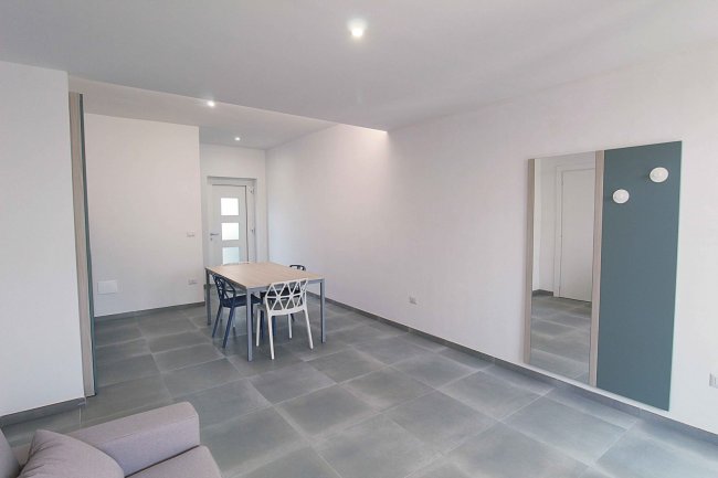 Stanza vuota con tavolo e specchio.