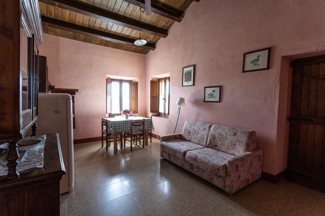 Salotto con divano floreale e tavolo da pranzo.