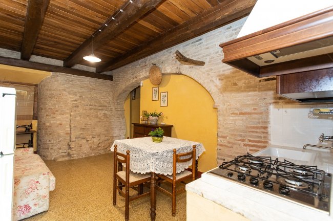 Cucina in stile rustico con tavolo e sedie.