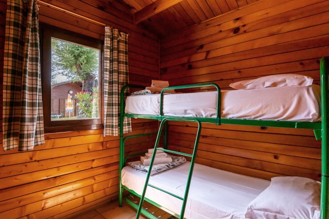 Letti a castello verdi in stanza di legno.
