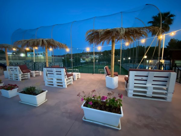 Terrazza con sedie e luci di sera.