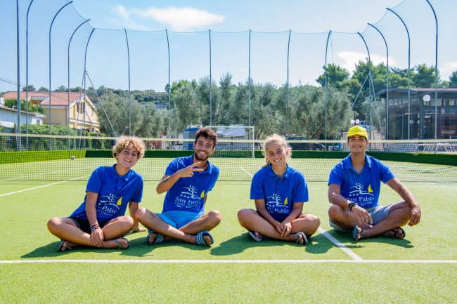 Quattro persone sedute su un campo da tennis.