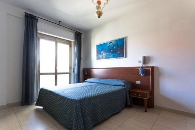 Camera da letto con letto matrimoniale e quadro.