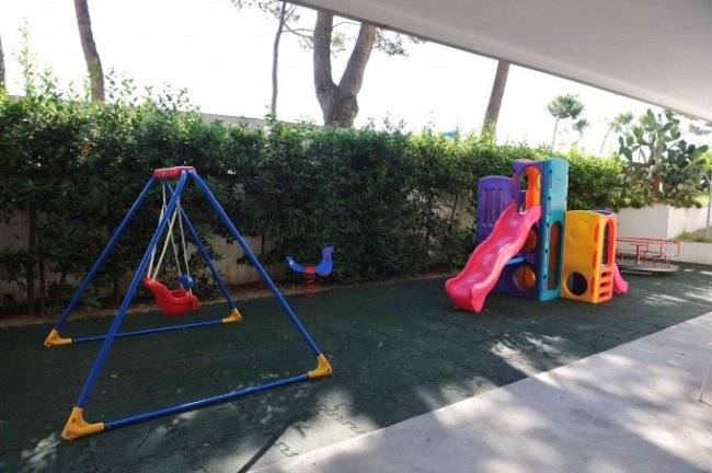 Area giochi per bambini con scivolo e altalena.