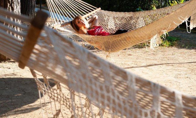 Persona in amaca sotto gli alberi.