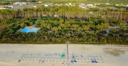 Una spiaggia sabbiosa con mare cristallino e una persona che cammina lontano.