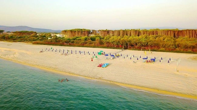 Spiaggia con ombrelloni e mare calmo.