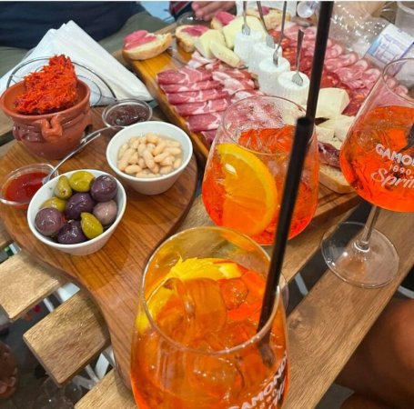Aperitivi spritz e tagliere di salumi su un tavolo.