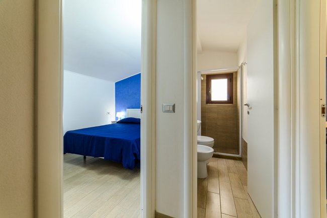 Camera con letto matrimoniale e bagno adiacente.