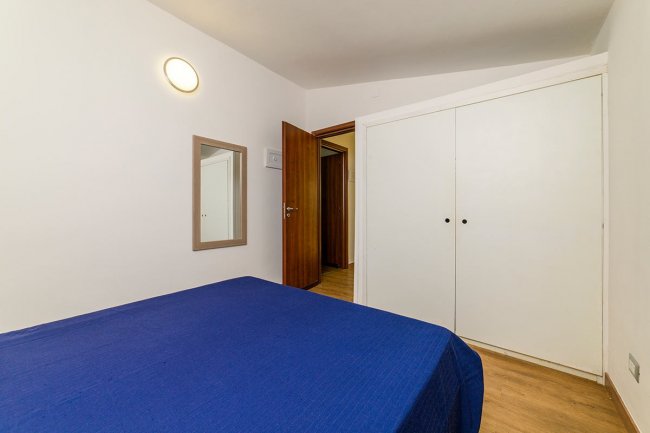 Camera da letto con armadio bianco e specchio.