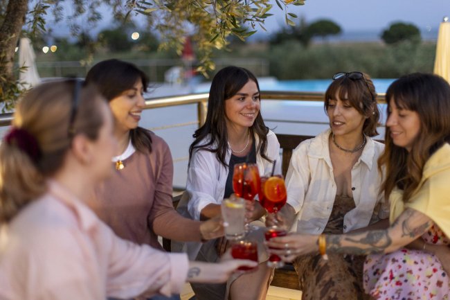 Gruppo di persone che brinda con drink serali.