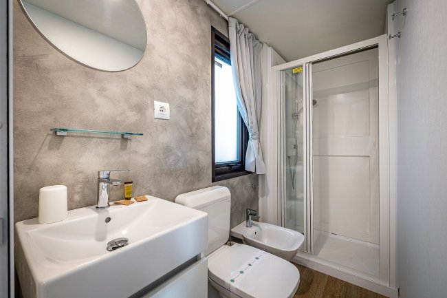 Bagno moderno con doccia, lavabo e bidet.