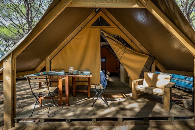 Interno tenda con tavolo e poltrona.