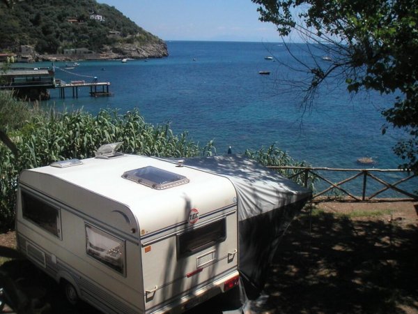 Roulotte parcheggiata vicino al mare con vista panoramica.