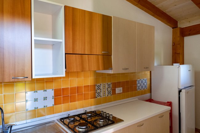 Cucina con fornelli e armadietti in legno.