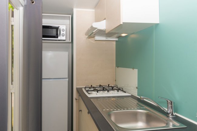 Angolo cottura compatto con fornelli e microonde.