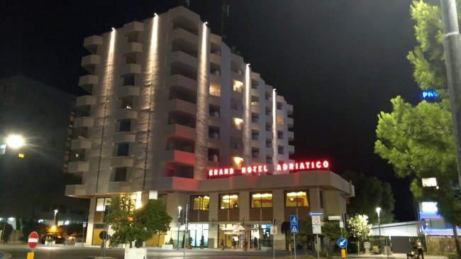 Un edificio moderno illuminato di notte con insegna 