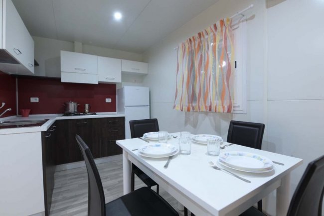 Cucina moderna con tavolo apparecchiato per quattro.