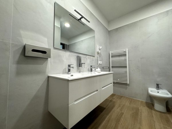 Bagno moderno con lavabo sospeso e specchio.