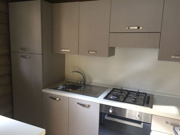 Cucina compatta con lavello e fornelli.