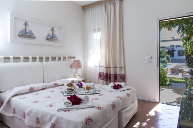 Stanza luminosa con letto e colazione servita.