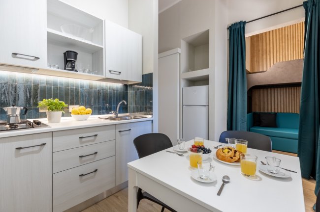 Cucina bianca con tavolo e colazione servita.
