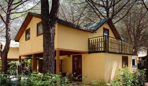 Casa gialla a due piani con balcone.