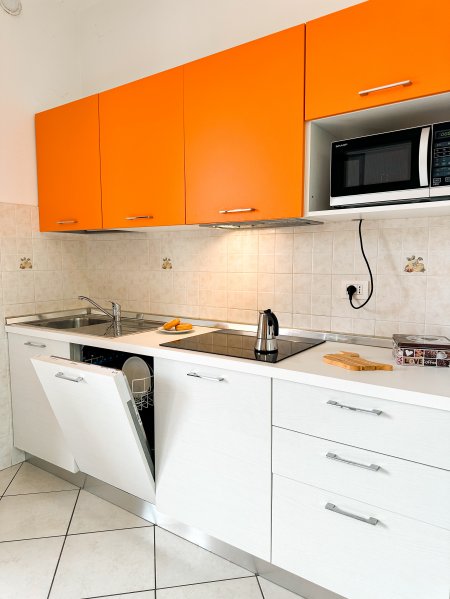 Cucina moderna con mobili arancioni.