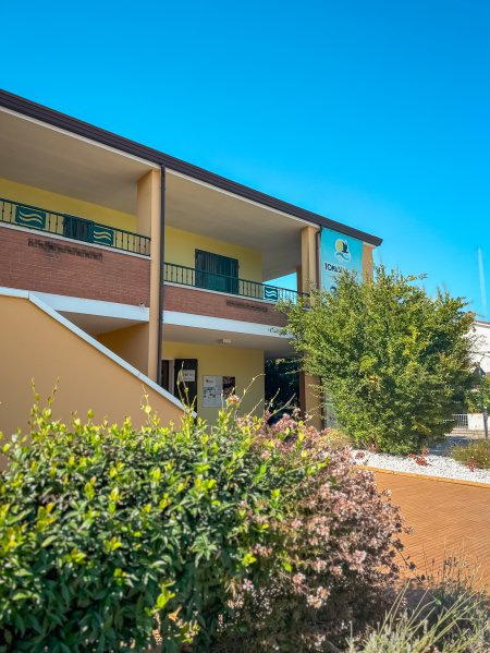 Edificio residenziale con giardino e balconi.