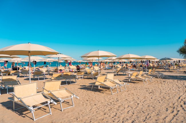 Spiaggia con lettini e ombrelloni.
