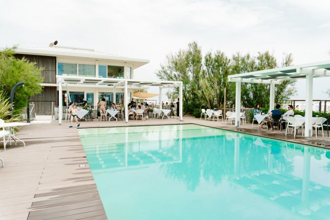 Piscina ampia con ristorante sullo sfondo.