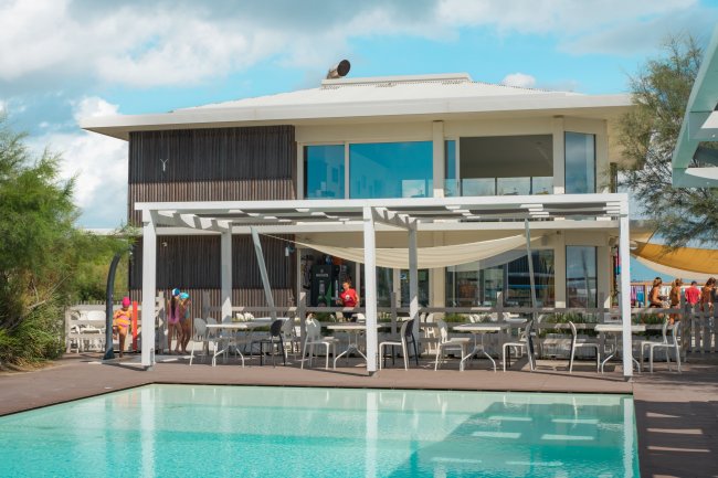 Edificio moderno con piscina e area coperta.