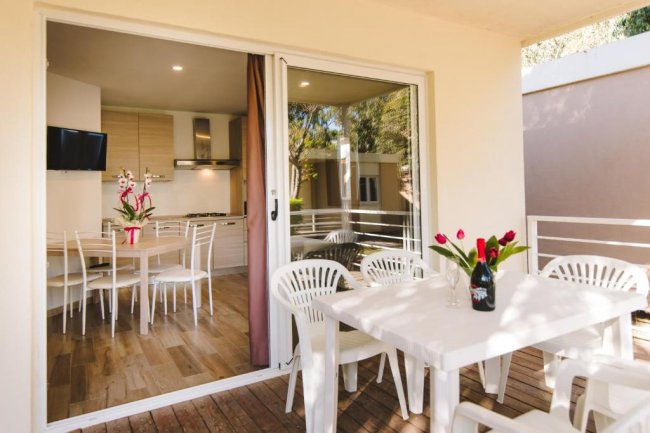 Terrazza con tavolo e sedie, vista cucina.