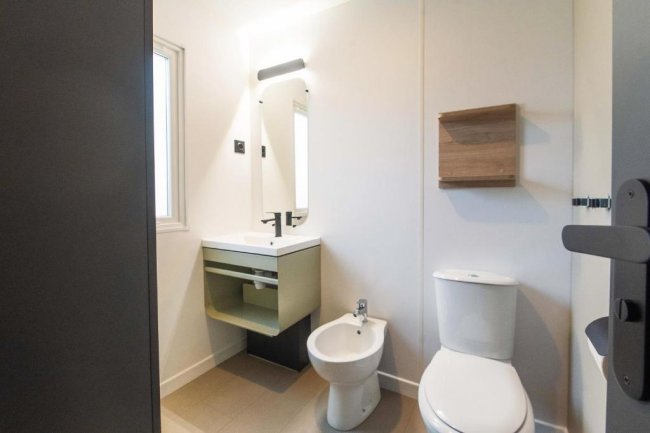 Bagno moderno con WC, bidet e specchio.