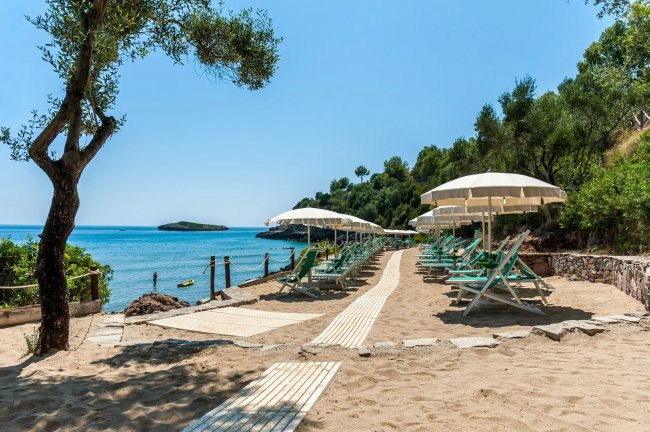 Spiaggia con ombrelloni e sedie a sdraio vicino al mare.