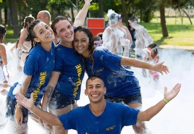 Persone sorridenti in una festa di schiuma.