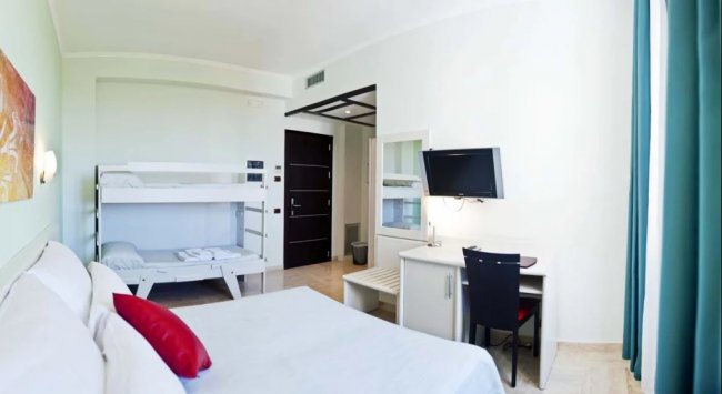Camera con letto matrimoniale, letti a castello e scrivania.