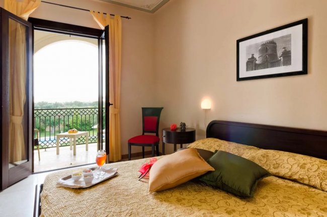 Camera con letto matrimoniale e balcone aperto.